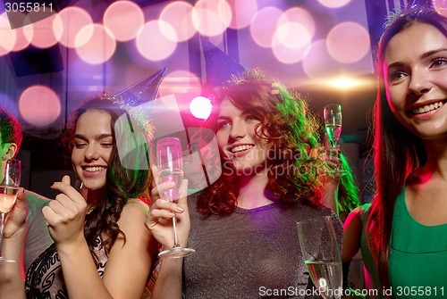 Image of smiling friends with glasses of champagne in club