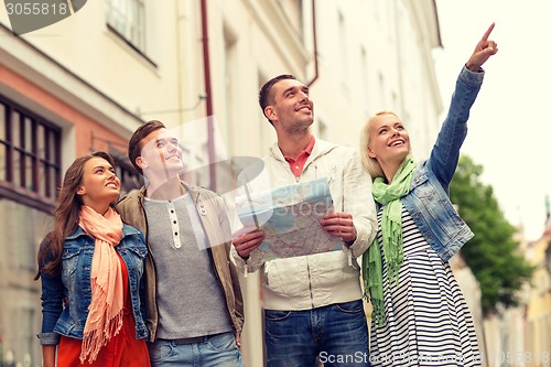 Image of group of smiling friends with map exploring city