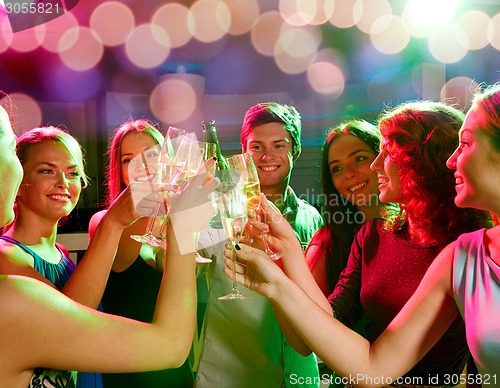 Image of smiling friends with wine glasses and beer in club