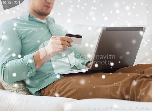 Image of close up of man with laptop and credit card