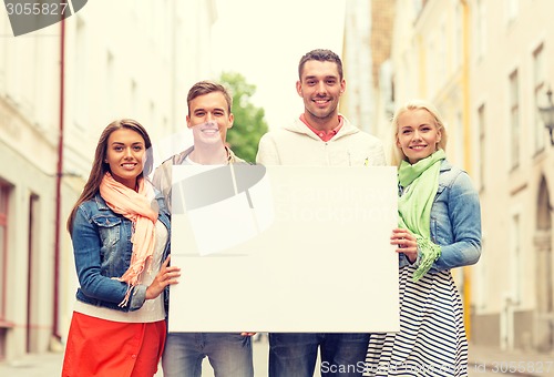 Image of group of smiling friends with blank white board
