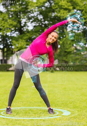 Image of smiling woman stretching back outdoors