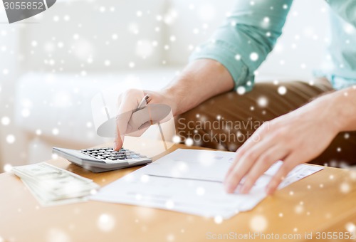 Image of close up of man counting money and making notes