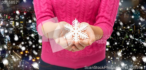 Image of close up of woman holding snowflake decoration