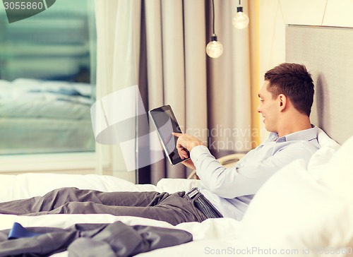 Image of happy businesswoman with tablet pc in hotel room