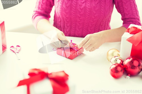 Image of close up of woman decorating christmas presents