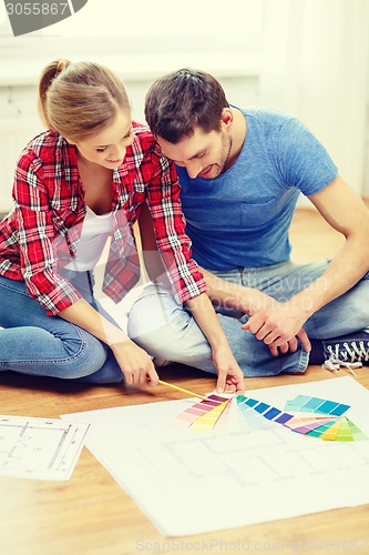 Image of smiling couple looking at color samples at home