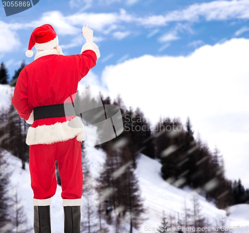 Image of man in costume of santa claus writing something