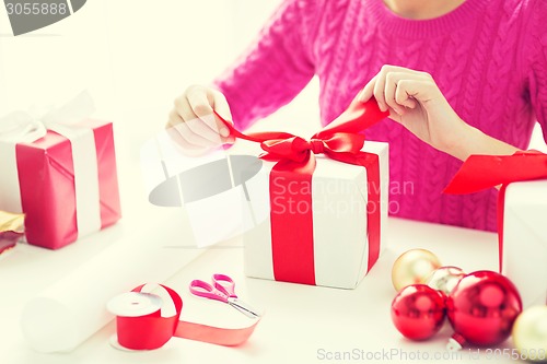 Image of close up of woman decorating christmas presents