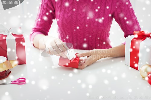 Image of close up of woman decorating christmas presents