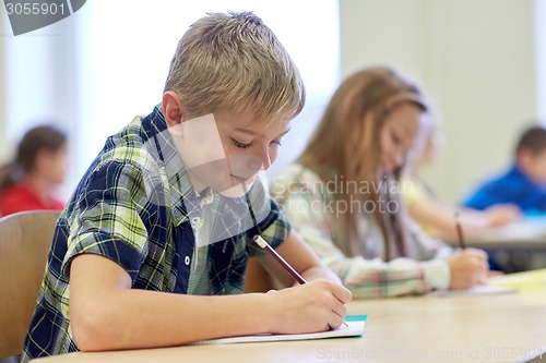 Image of group of school kids writing test in classroom