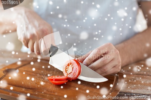 Image of close up of man cutting vegetables with knife