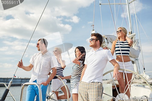 Image of smiling friends sailing on yacht