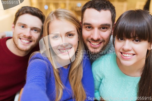 Image of group of smiling friends taking selfie