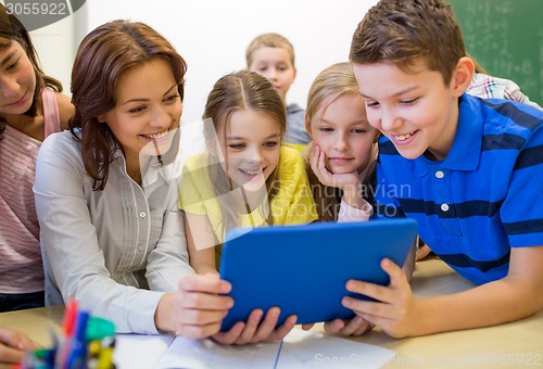 Image of group of kids with teacher and tablet pc at school