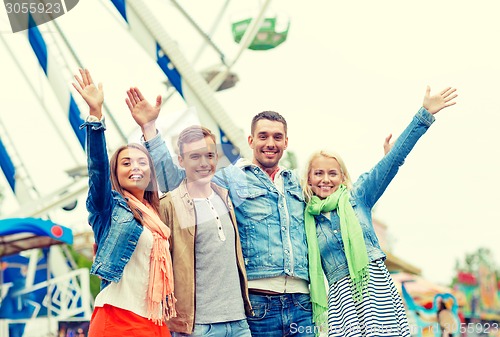 Image of group of smiling friends waving hands