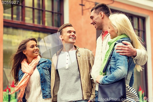 Image of group of smiling friends walking in the city