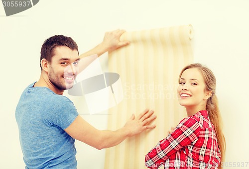 Image of smiling couple choosing wallpaper for new home