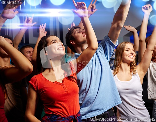 Image of smiling friends at concert in club