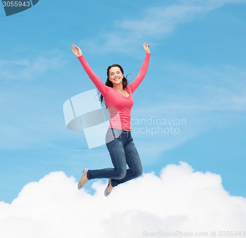 Image of smiling young woman jumping in air