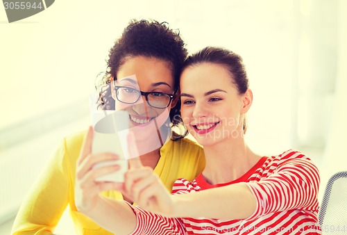 Image of girlfriends taking selfie with smartphone camera