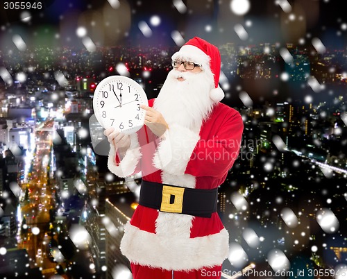 Image of man in costume of santa claus with clock