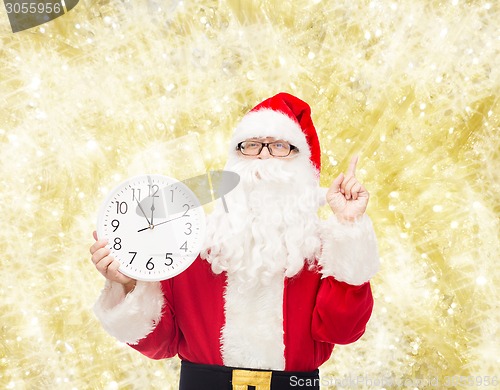 Image of man in costume of santa claus with clock