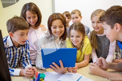 Image of group of kids with teacher and tablet pc at school