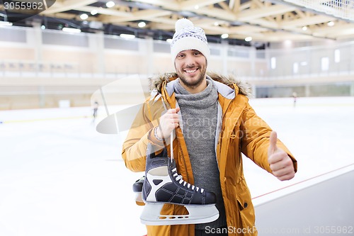 Image of happy young man showing thumbs up on skating rink