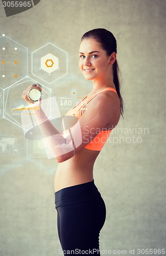 Image of smiling woman with dumbbells in gym