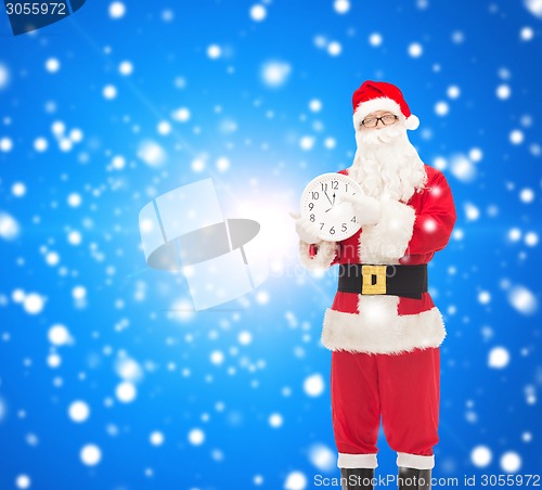 Image of man in costume of santa claus with clock