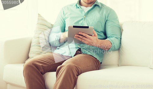 Image of close up of man with tablet pc computer at home