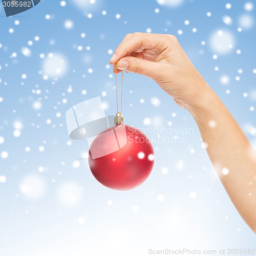 Image of close up of woman in sweater with christmas ball