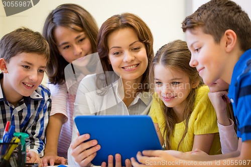 Image of group of kids with teacher and tablet pc at school