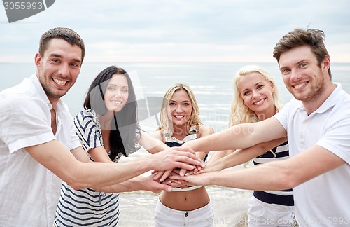 Image of smiling friends putting hands on top of each other