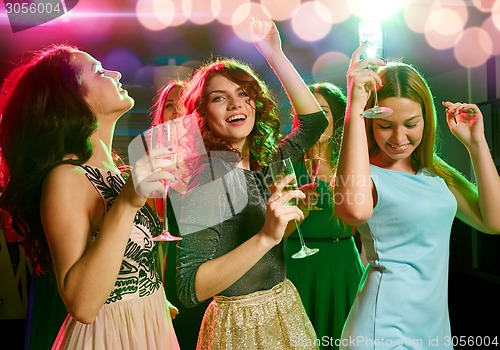 Image of smiling friends with glasses of champagne in club