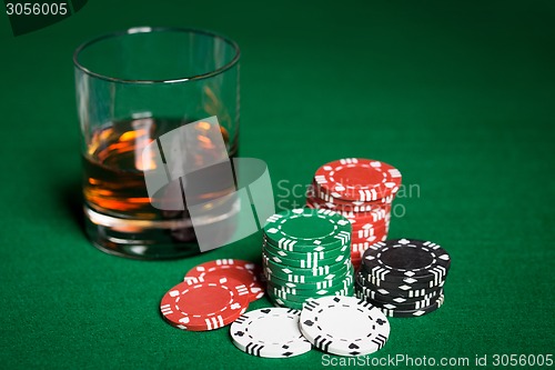 Image of close up of casino chips and whisky glass on table