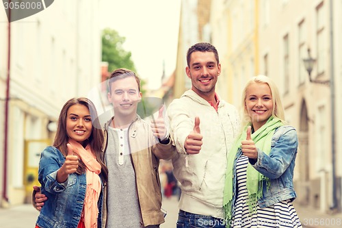 Image of group of smiling friends showing thumbs up