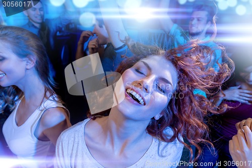 Image of smiling friends dancing in club