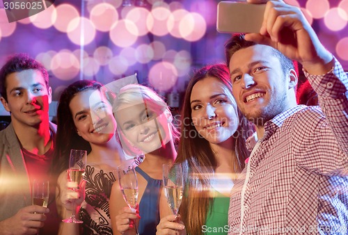 Image of friends with glasses and smartphone in club