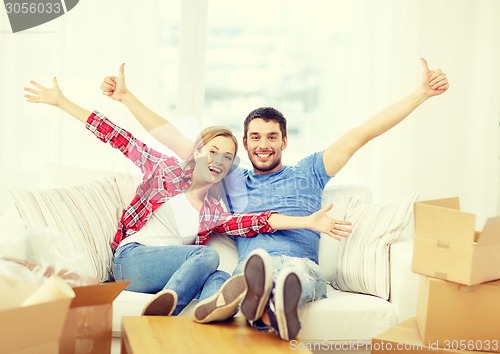 Image of smiling couple relaxing on sofa in new home