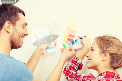 Image of smiling couple looking at color samples at home