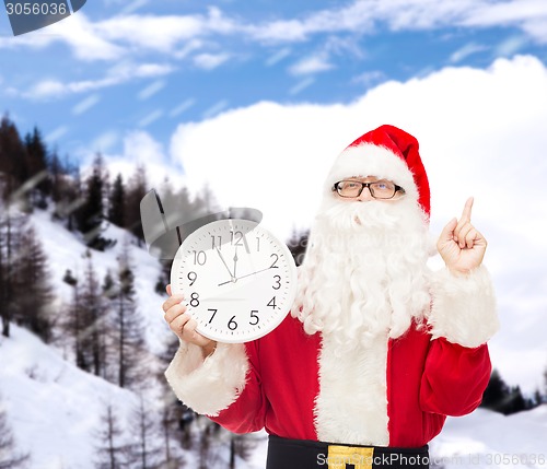 Image of man in costume of santa claus with clock