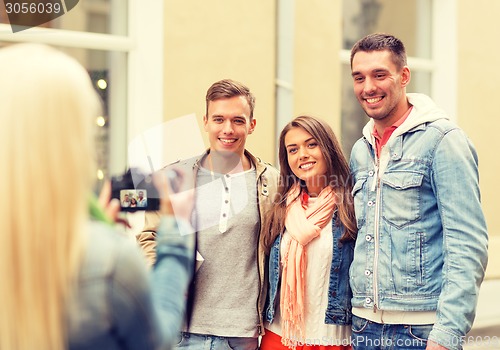 Image of group of smiling friends taking photo outdoors