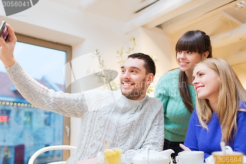 Image of group of friends taking selfie with smartphone