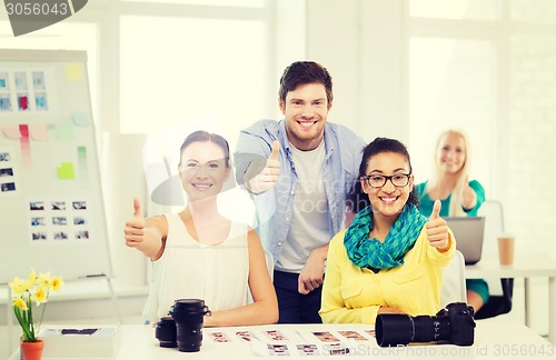 Image of smiling team with photocamera in office