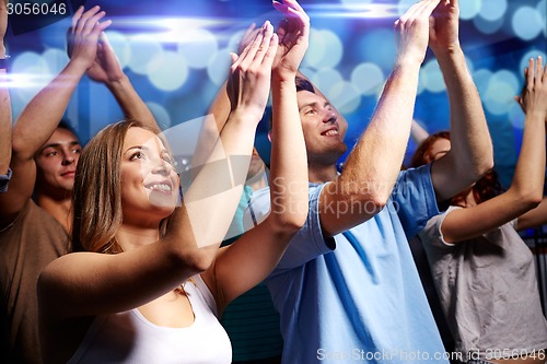 Image of smiling friends at concert in club