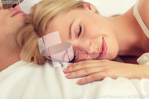 Image of happy couple sleeping in bed