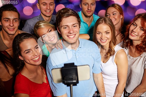 Image of friends with smartphone taking selfie in club