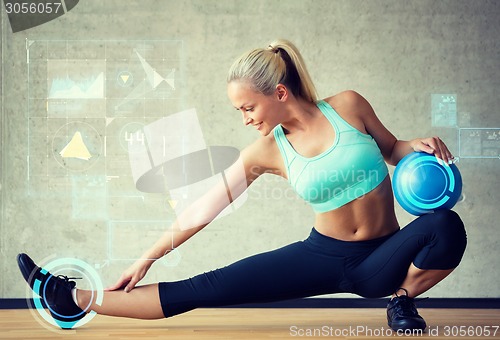 Image of smiling woman with exercise ball in gym